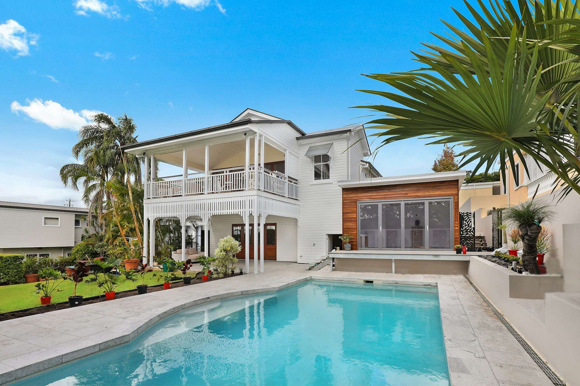 Piscine rénovée devant une maison blanche avec palmiers